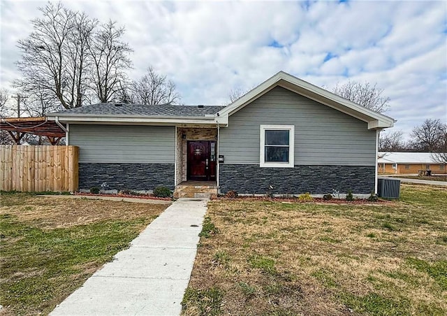 view of front of property with a front yard and central AC unit