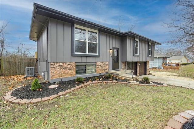 split foyer home featuring central AC and a front lawn