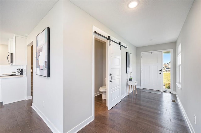 entryway featuring a barn door and dark hardwood / wood-style flooring