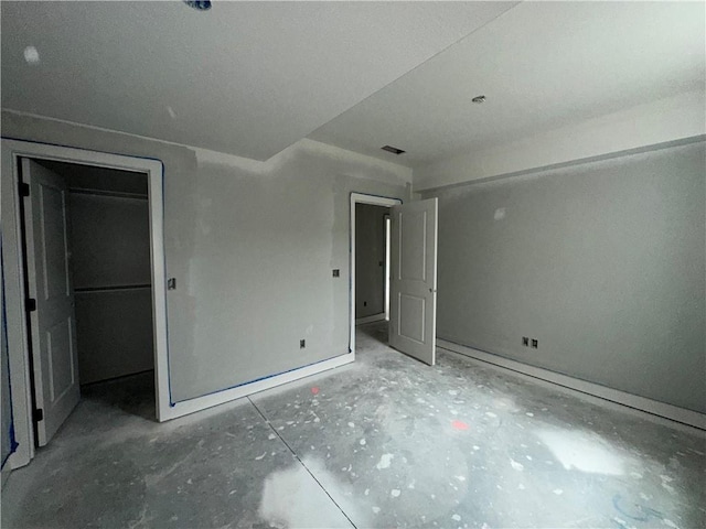 unfurnished bedroom with a walk in closet and a closet