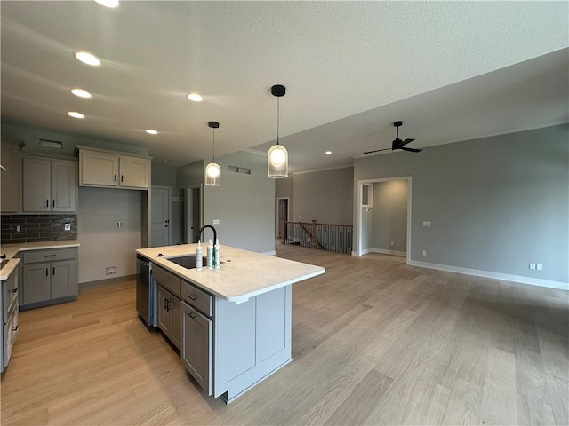 7050 NW Yulich Ct, Parkville, MO 64152 - kitchen with light countertops, gray cabinets, a sink, light wood-style flooring, and dishwasher