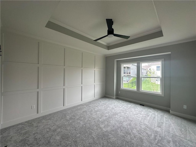 7050 NW Yulich Ct, Parkville, MO 64152 - carpeted spare room featuring crown molding, ceiling fan, a decorative wall, and a tray ceiling