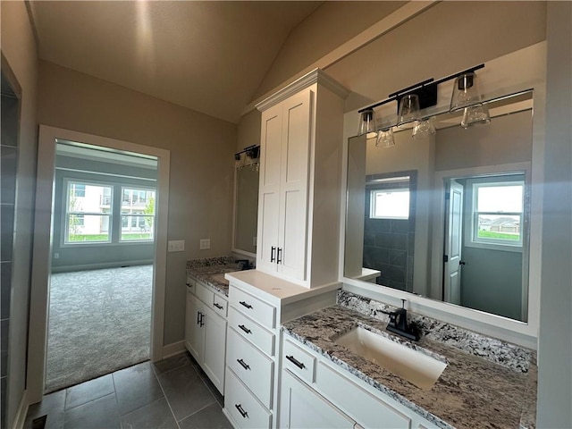 7050 NW Yulich Ct, Parkville, MO 64152 - full bath featuring tile patterned flooring, two vanities, a sink, baseboards, and lofted ceiling