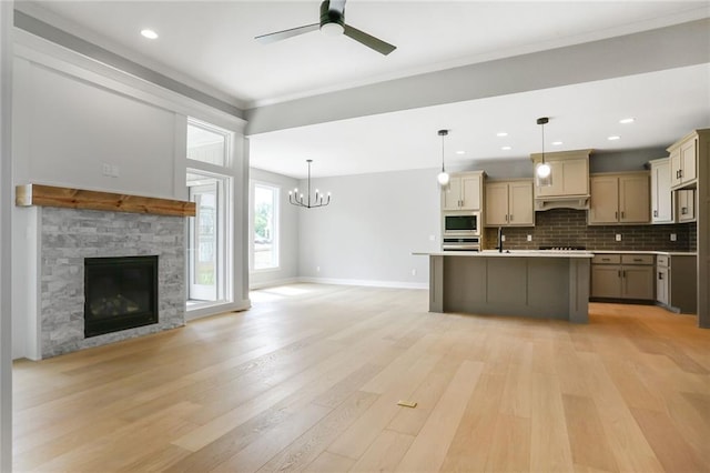 7050 NW Yulich Ct, Parkville, MO 64152 - kitchen with built in microwave, open floor plan, oven, a ceiling fan, and a stone fireplace