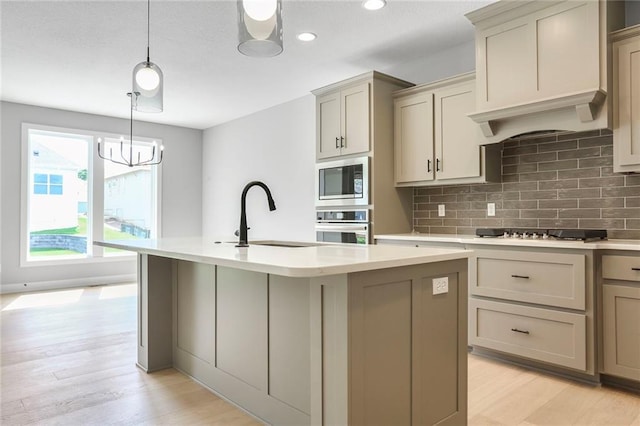7050 NW Yulich Ct, Parkville, MO 64152 - kitchen featuring stainless steel appliances, light countertops, decorative backsplash, light wood-style floors, and gray cabinets
