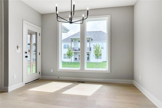 7050 NW Yulich Ct, Parkville, MO 64152 - unfurnished dining area with light wood-style floors and a chandelier