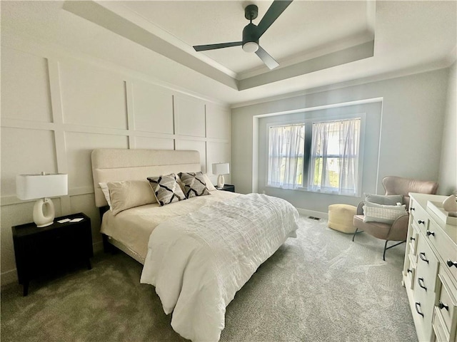 7050 NW Yulich Ct, Parkville, MO 64152 - bedroom featuring a raised ceiling, dark colored carpet, ornamental molding, a ceiling fan, and a decorative wall