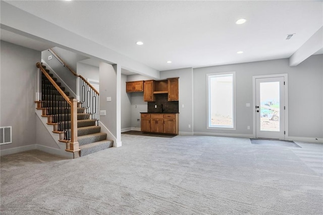 7050 NW Yulich Ct, Parkville, MO 64152 - unfurnished living room with light colored carpet, stairway, and recessed lighting