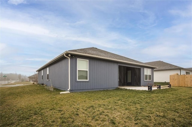 rear view of property featuring a patio and a lawn