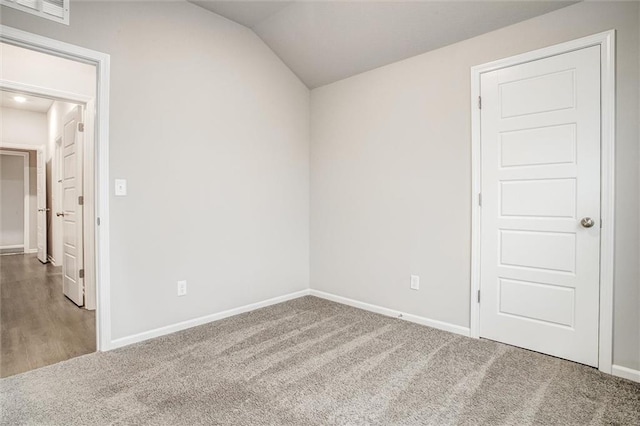 spare room with carpet flooring and vaulted ceiling