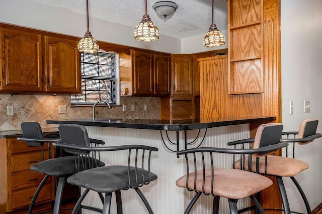 kitchen with tasteful backsplash, a textured ceiling, and a kitchen breakfast bar