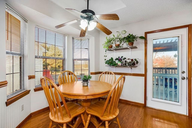 dining room with hardwood / wood-style floors, a textured ceiling, and ceiling fan