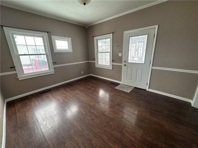 foyer entrance with dark wood-type flooring, crown molding, and a wealth of natural light