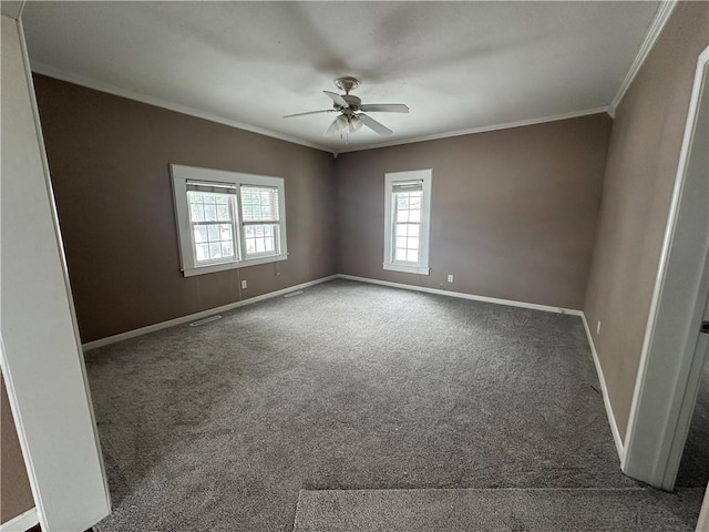 spare room featuring ceiling fan, crown molding, and dark carpet