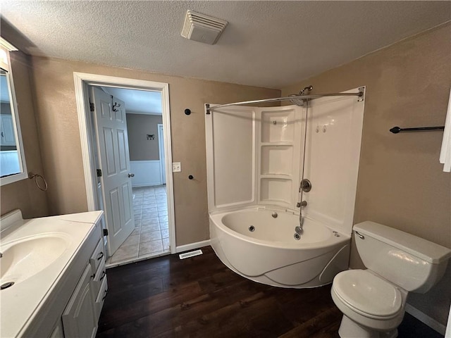 full bathroom with toilet, hardwood / wood-style flooring, a textured ceiling,  shower combination, and vanity