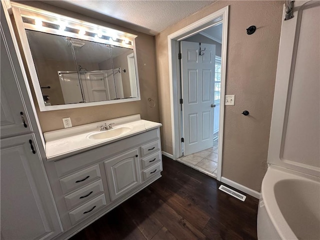 bathroom featuring a textured ceiling, vanity, and wood-type flooring