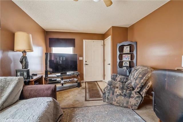 living room with carpet floors, ceiling fan, and a textured ceiling