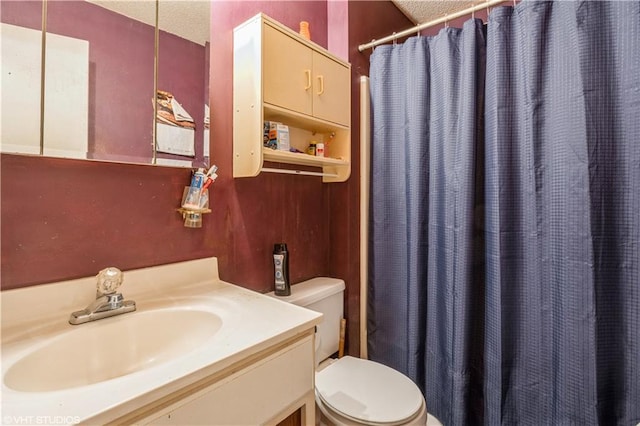 bathroom featuring a textured ceiling, toilet, and vanity