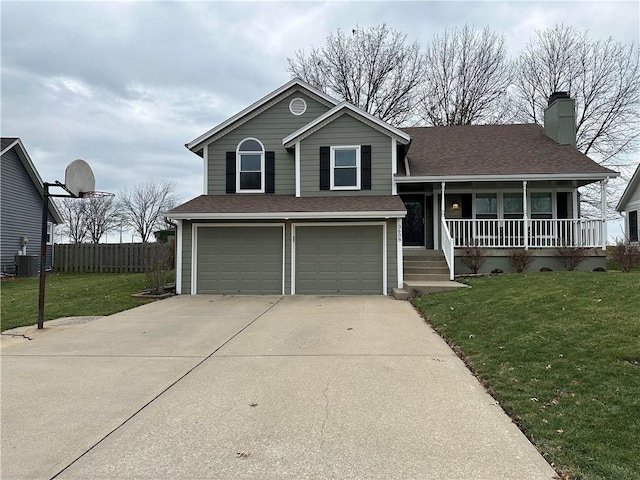 tri-level home featuring central air condition unit, a front yard, a garage, and a porch