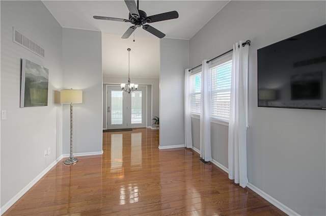 unfurnished living room with hardwood / wood-style floors and ceiling fan with notable chandelier