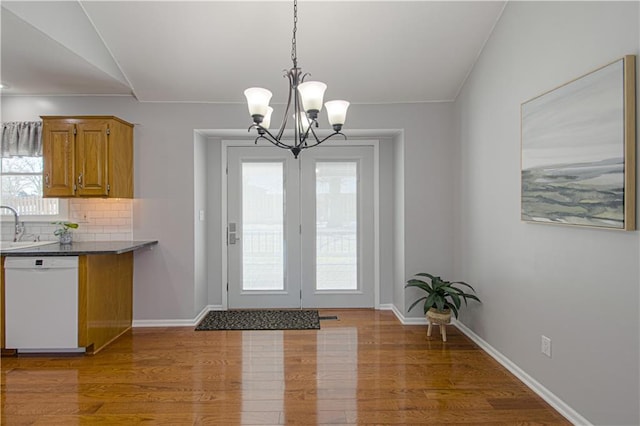 interior space featuring lofted ceiling, a notable chandelier, wood-type flooring, and sink