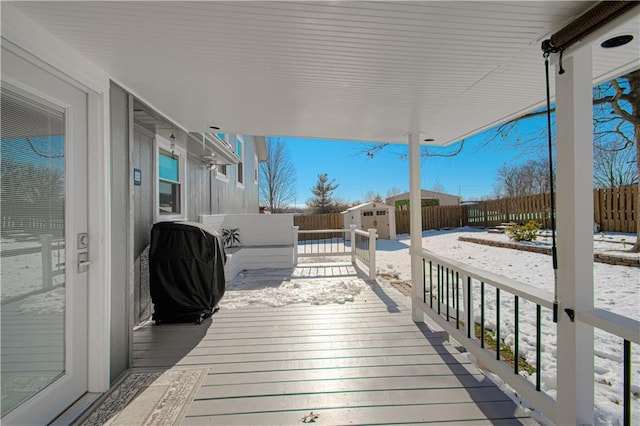 deck with a shed and area for grilling