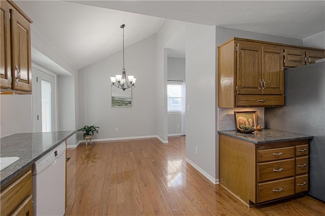 kitchen with vaulted ceiling, a chandelier, hanging light fixtures, white dishwasher, and light hardwood / wood-style flooring