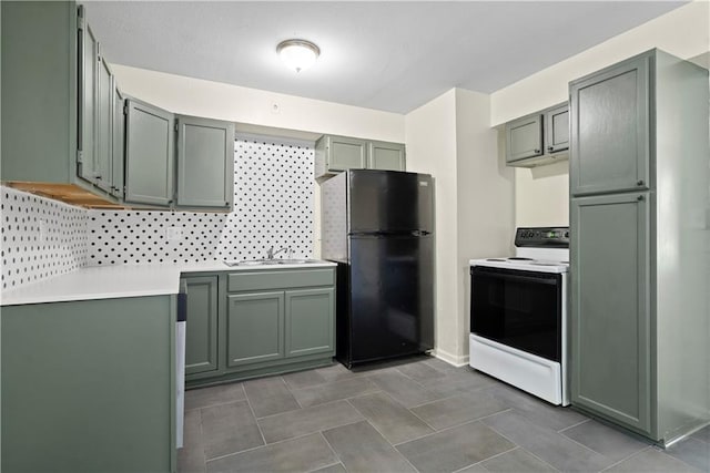 kitchen with backsplash, electric stove, black refrigerator, and sink