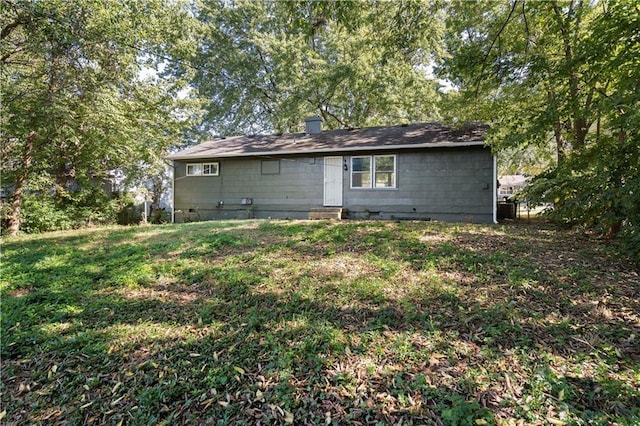 rear view of property featuring a yard