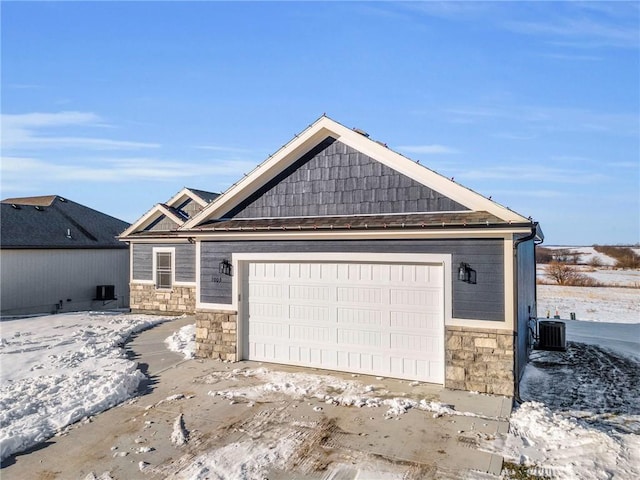 view of front of home with a garage and central air condition unit