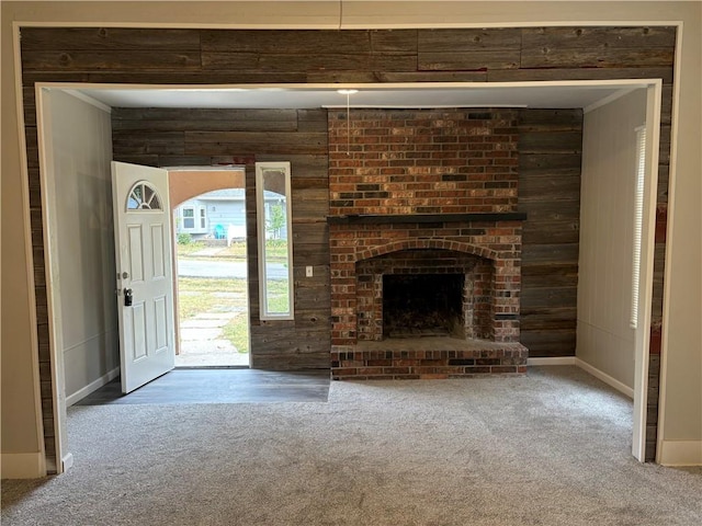 unfurnished living room with carpet and a fireplace