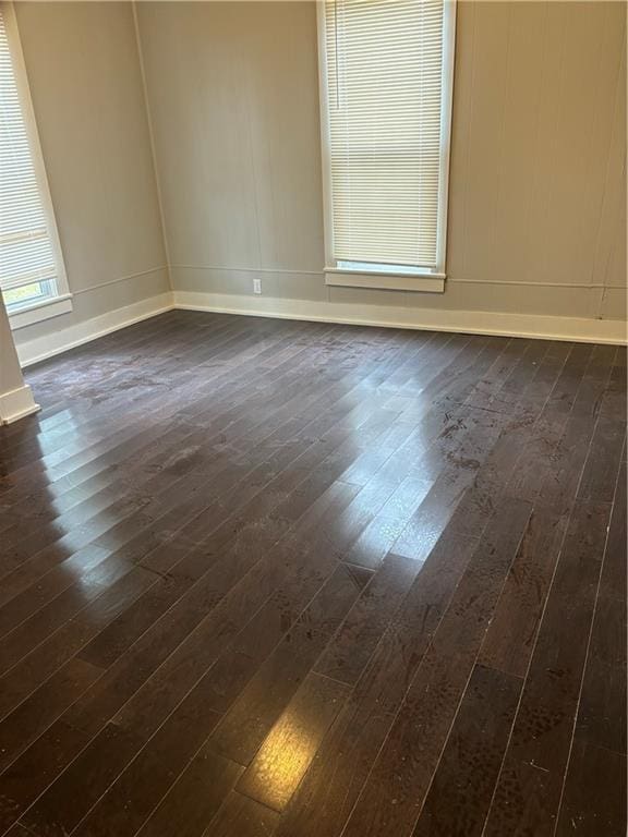 unfurnished room with dark wood-type flooring