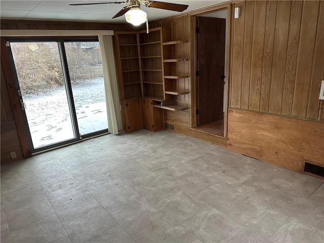 empty room with wooden walls and ceiling fan