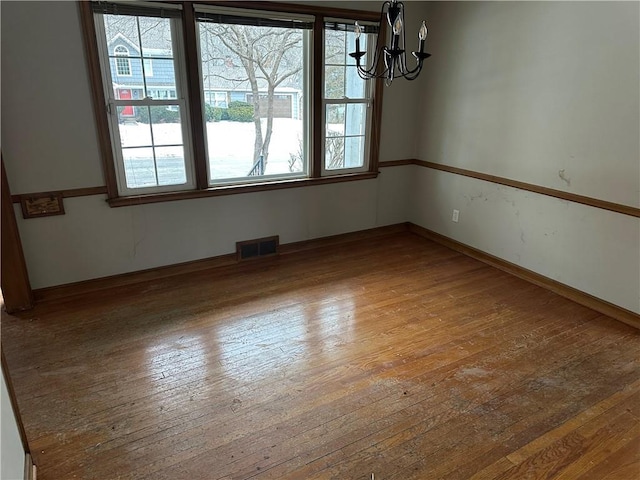 unfurnished dining area featuring wood-type flooring and a chandelier