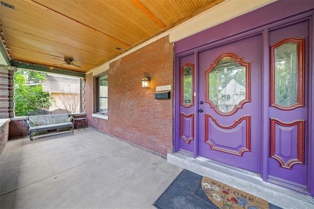 property entrance with brick siding and a porch