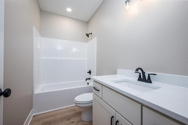 full bathroom featuring hardwood / wood-style floors, toilet, bathing tub / shower combination, and vanity