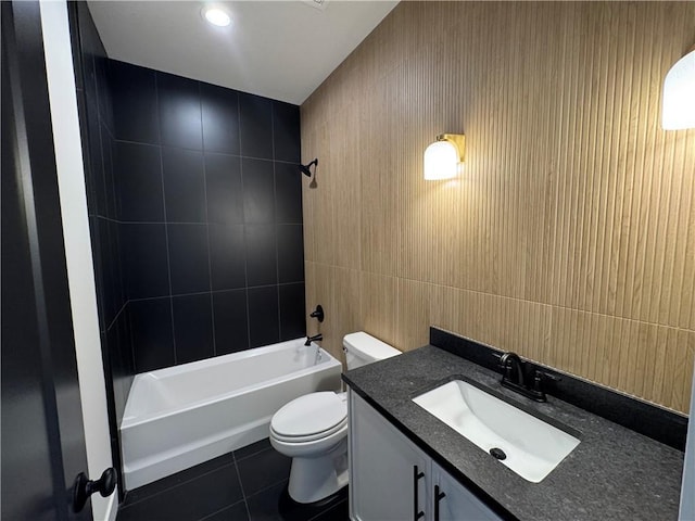 full bathroom with toilet, tile patterned floors, vanity, tile walls, and shower / bathing tub combination