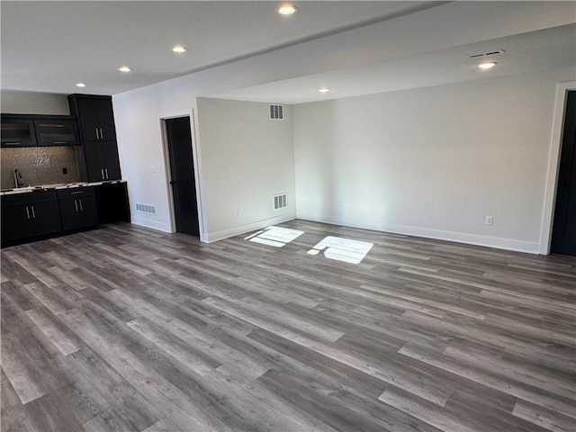 unfurnished living room featuring light wood-type flooring and sink