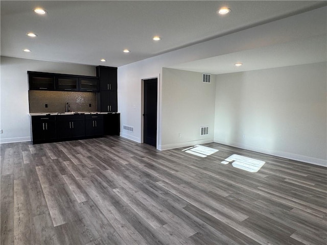 unfurnished living room featuring sink and hardwood / wood-style floors