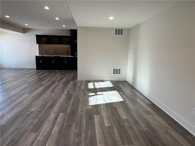 unfurnished living room featuring sink and dark hardwood / wood-style floors