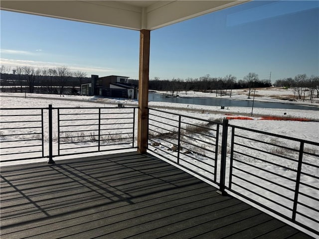 snow covered deck featuring a water view