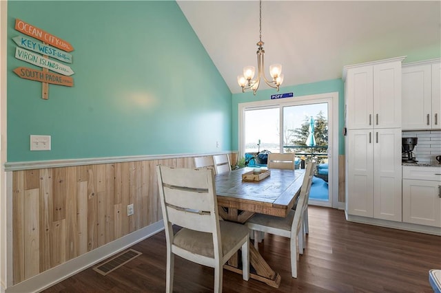 dining room with lofted ceiling, dark wood-type flooring, and a chandelier