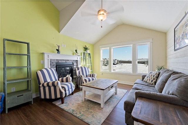 living room with a stone fireplace, ceiling fan, dark hardwood / wood-style flooring, and vaulted ceiling