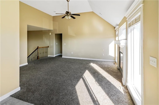 unfurnished living room with ceiling fan, a fireplace, high vaulted ceiling, and dark carpet