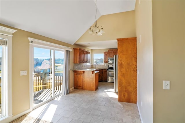 kitchen with kitchen peninsula, backsplash, a notable chandelier, hanging light fixtures, and stainless steel range with electric cooktop