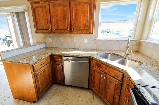 kitchen with light stone countertops, sink, stainless steel dishwasher, kitchen peninsula, and decorative backsplash