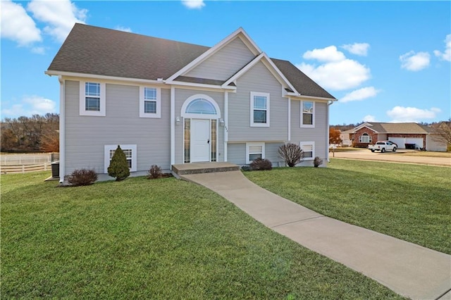 bi-level home with a front yard and roof with shingles