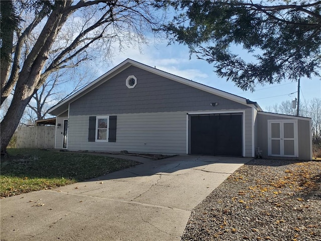 view of front of house featuring a garage, driveway, and fence