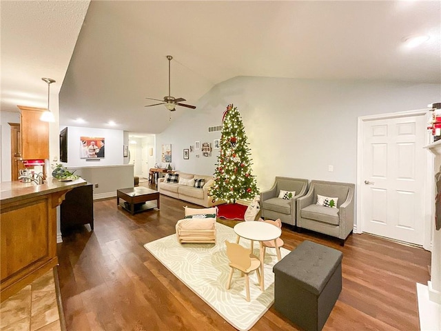 living room featuring ceiling fan, wood-type flooring, and lofted ceiling