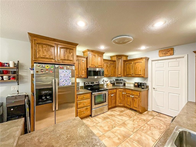 kitchen featuring stainless steel appliances and a textured ceiling